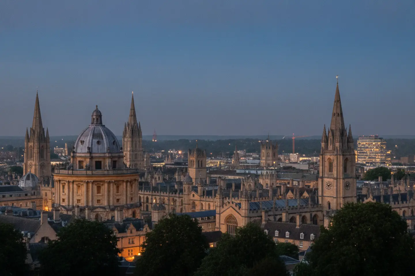 Oxford's stone spires and domes seen from a hill at dusk